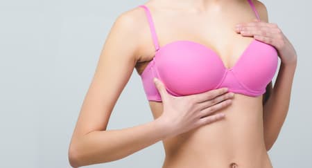 Mulher de sutiã rosa representando mamoplastia de aumento